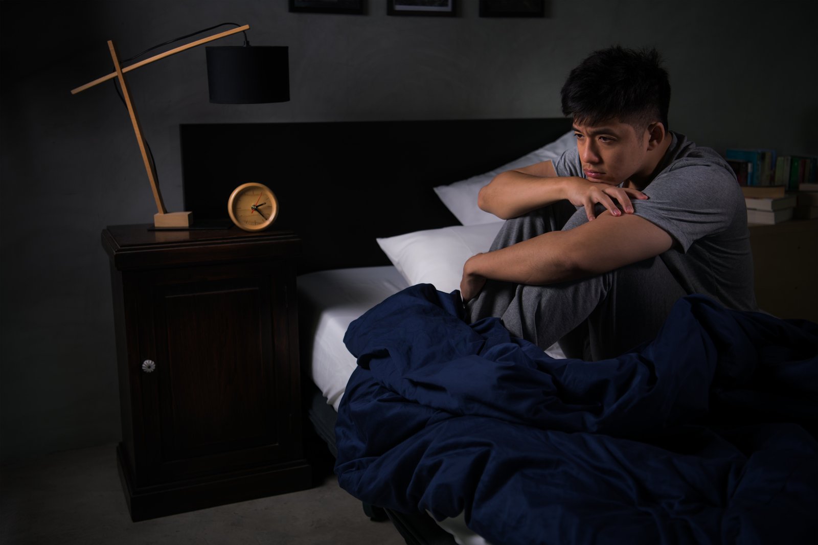 Person sitzt nachts frustriert im Bett