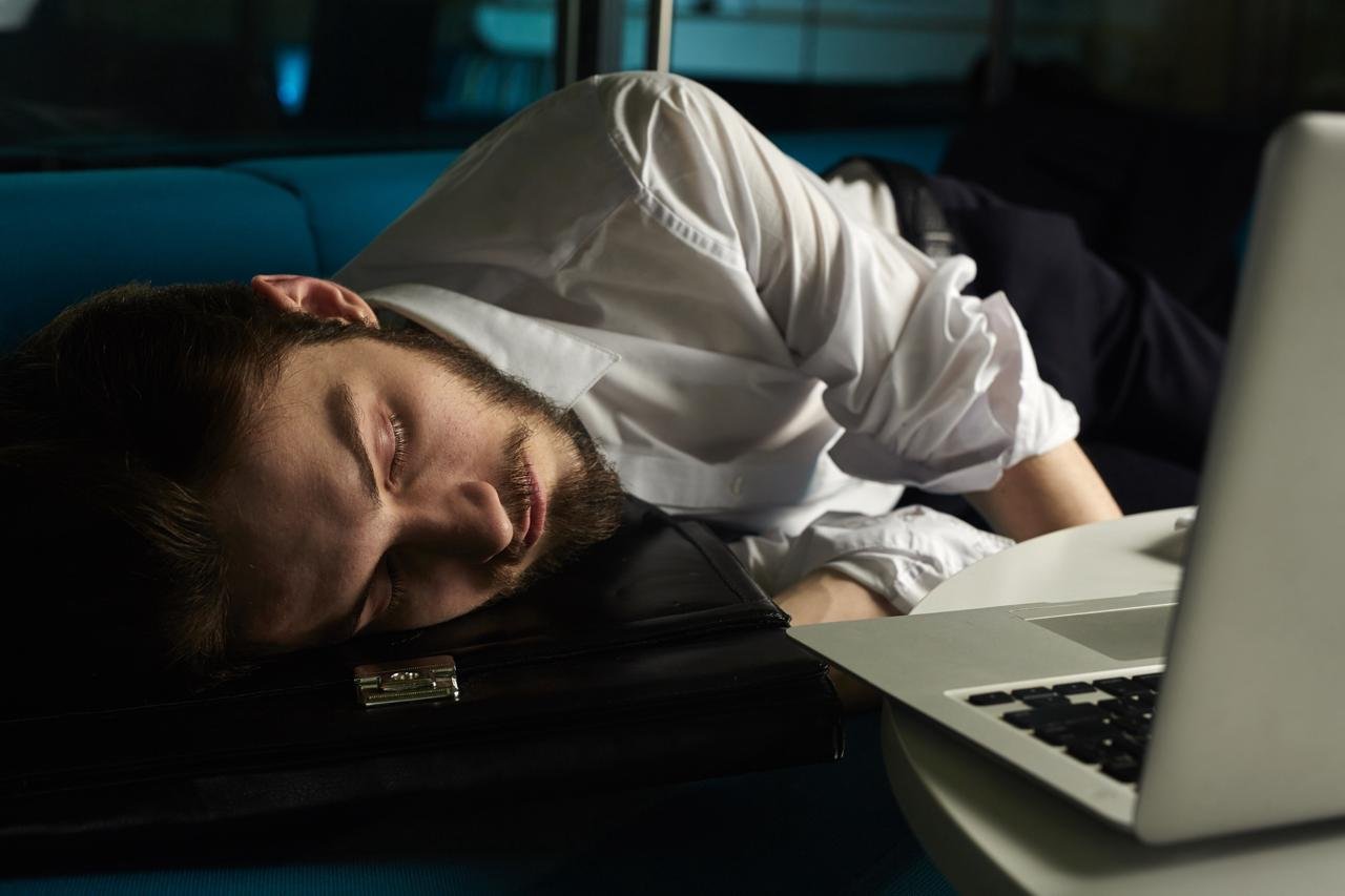 Erschöpfte Person mit Kopfschmerzen am Morgen