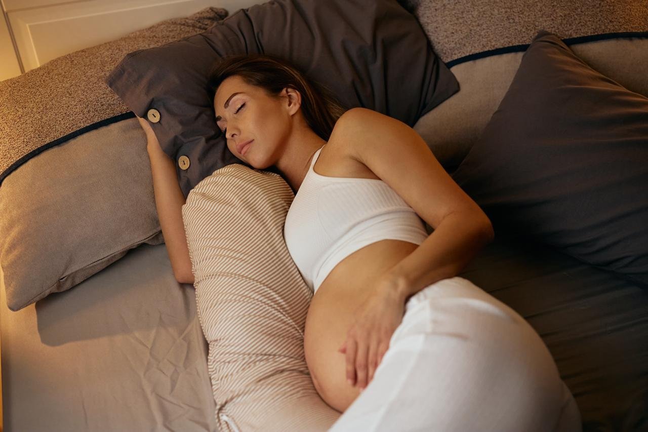 Schwangere Frau schläft im Bett